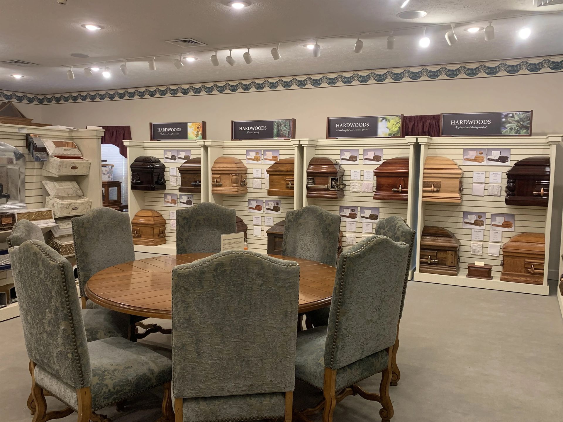 a dining room with a table and chairs in front of a display of coffins .