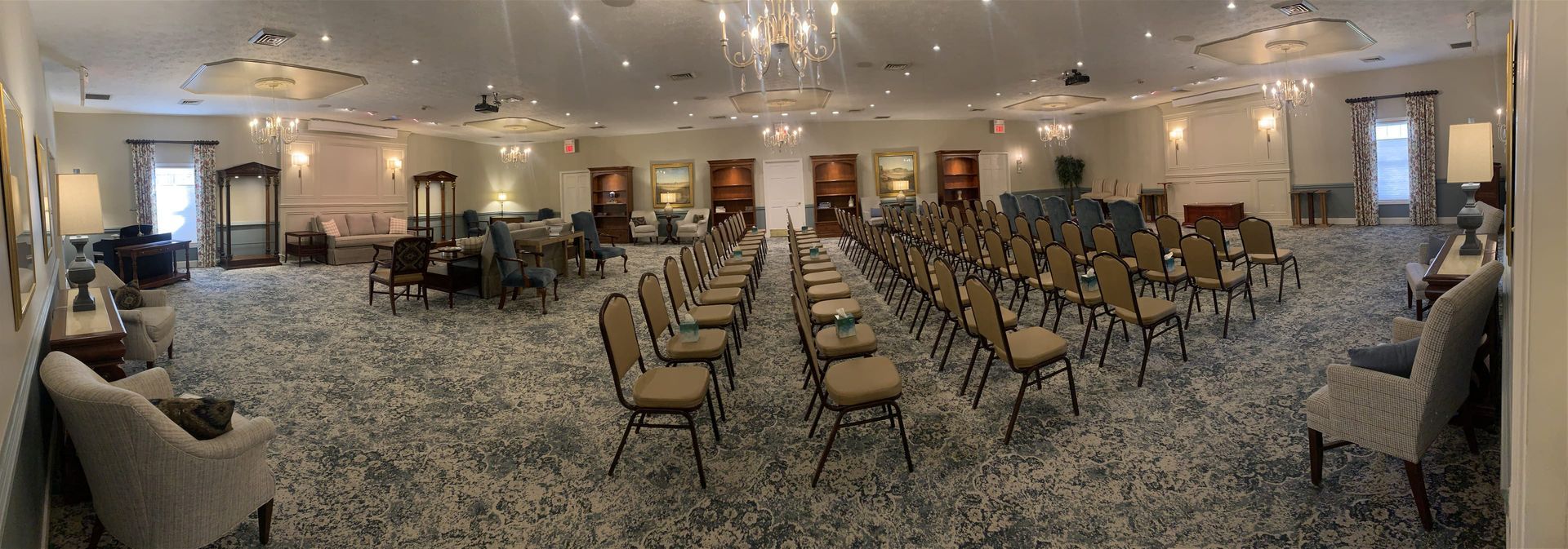 a large room filled with chairs and a chandelier .
