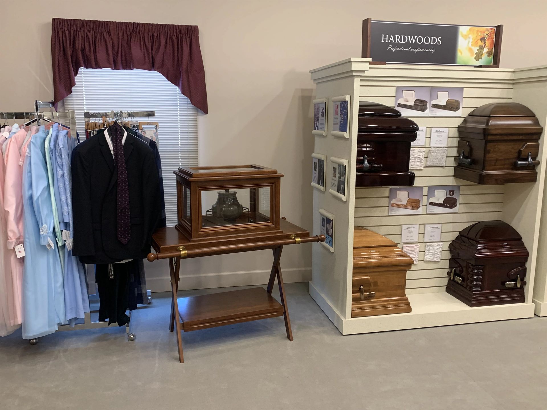 a display of coffins and clothes in a funeral home .