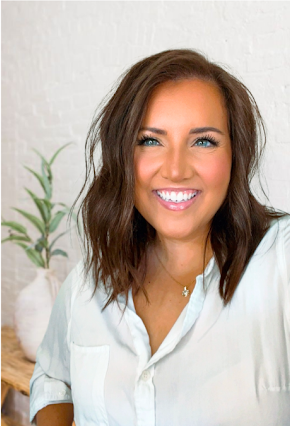 A woman in a green shirt is smiling for the camera.