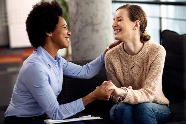 Two women are sitting at a table having a conversation.