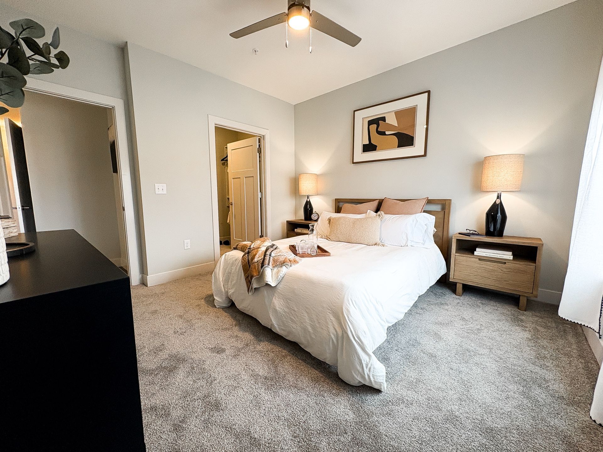 A bedroom with a large bed and a ceiling fan.