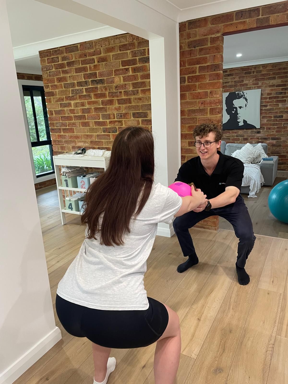 A man and a woman are squatting in a living room.