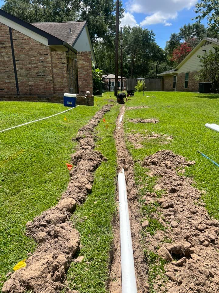 A hose is being installed in a yard next to a house.