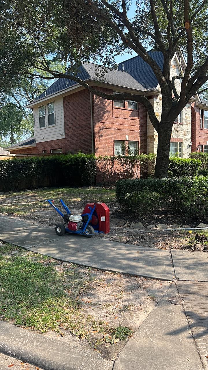 A lawn mower is parked on the sidewalk in front of a house.