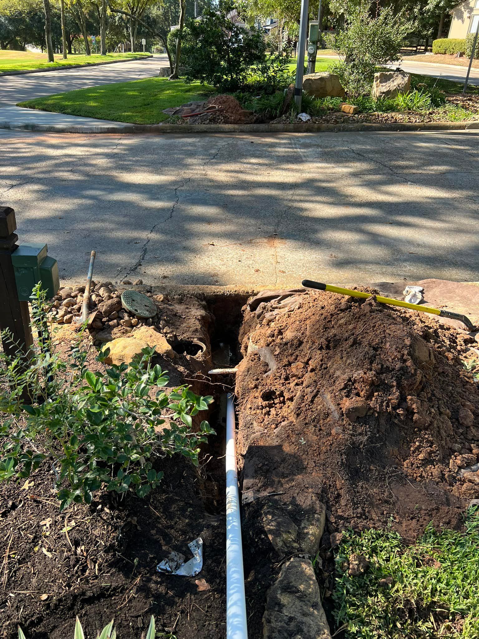 A pipe is being installed in the ground next to a road.