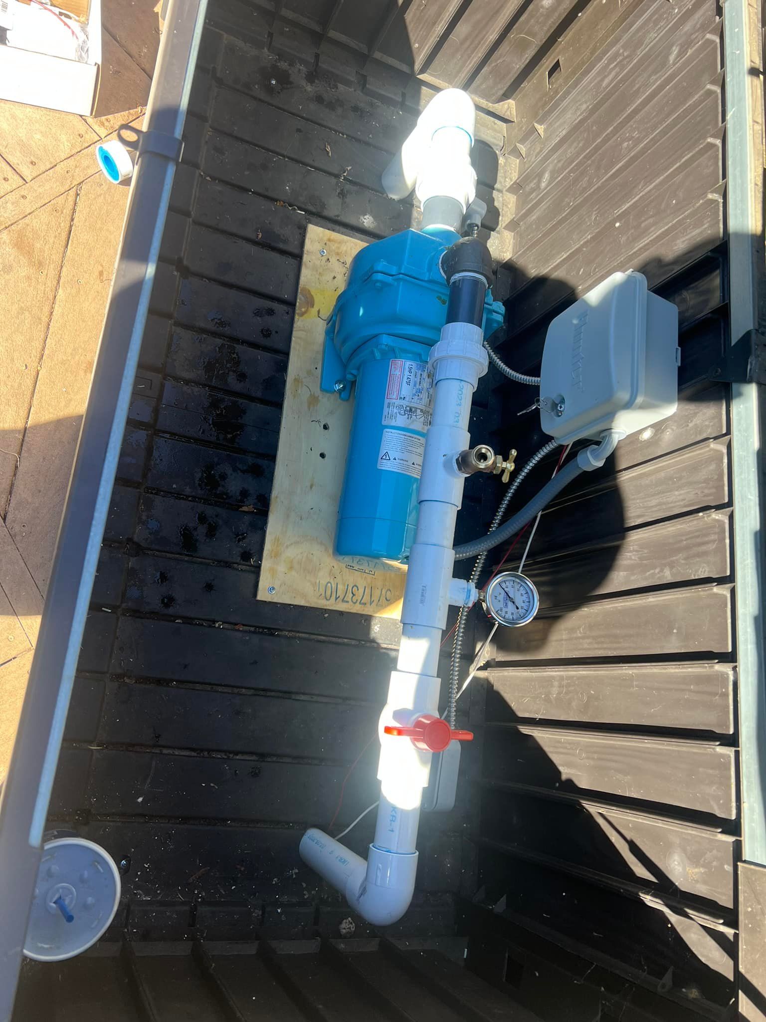 A blue and white pipe is sitting on top of a wooden deck.