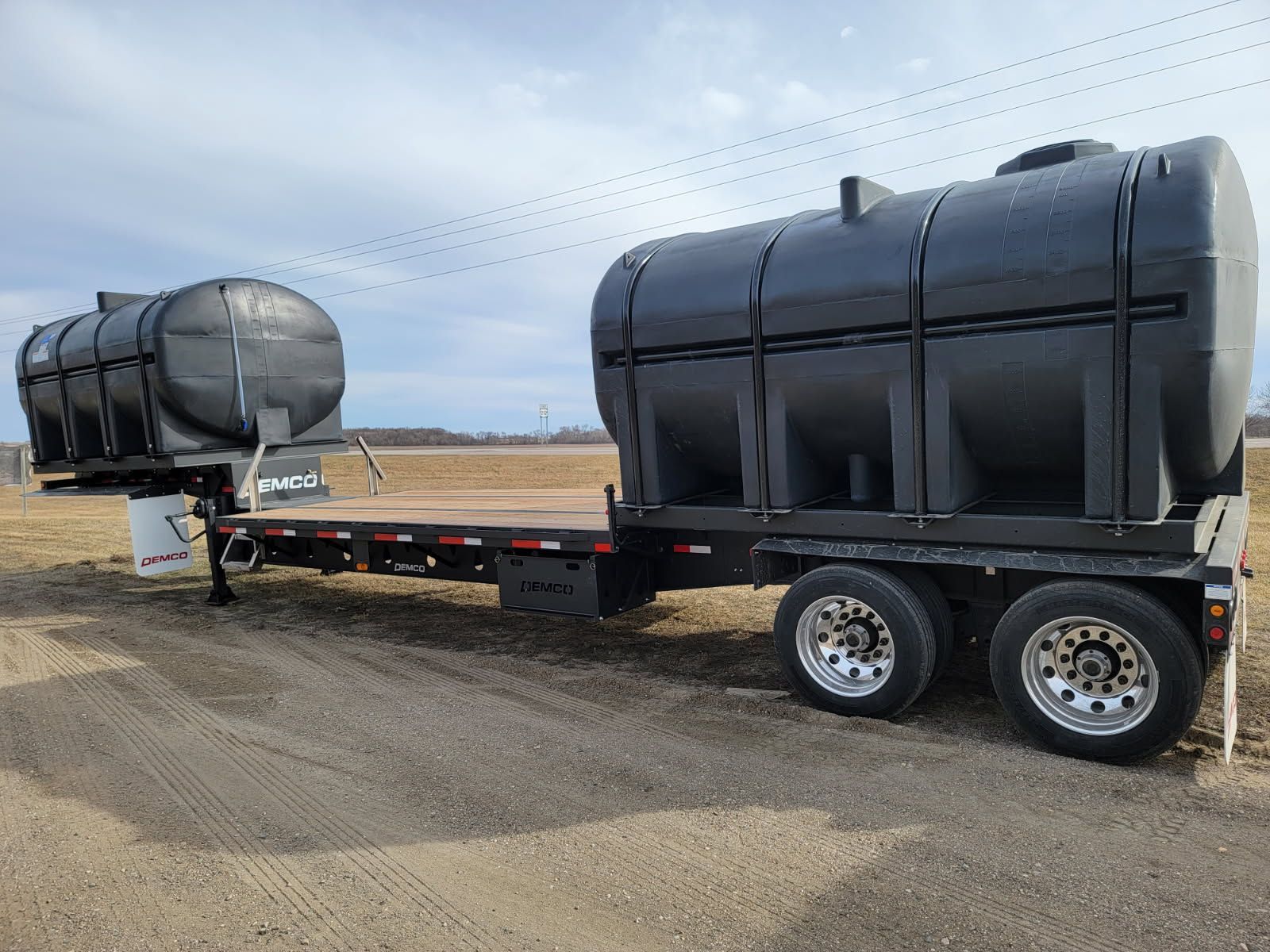 A trailer with two tanks attached to it is parked in a field.