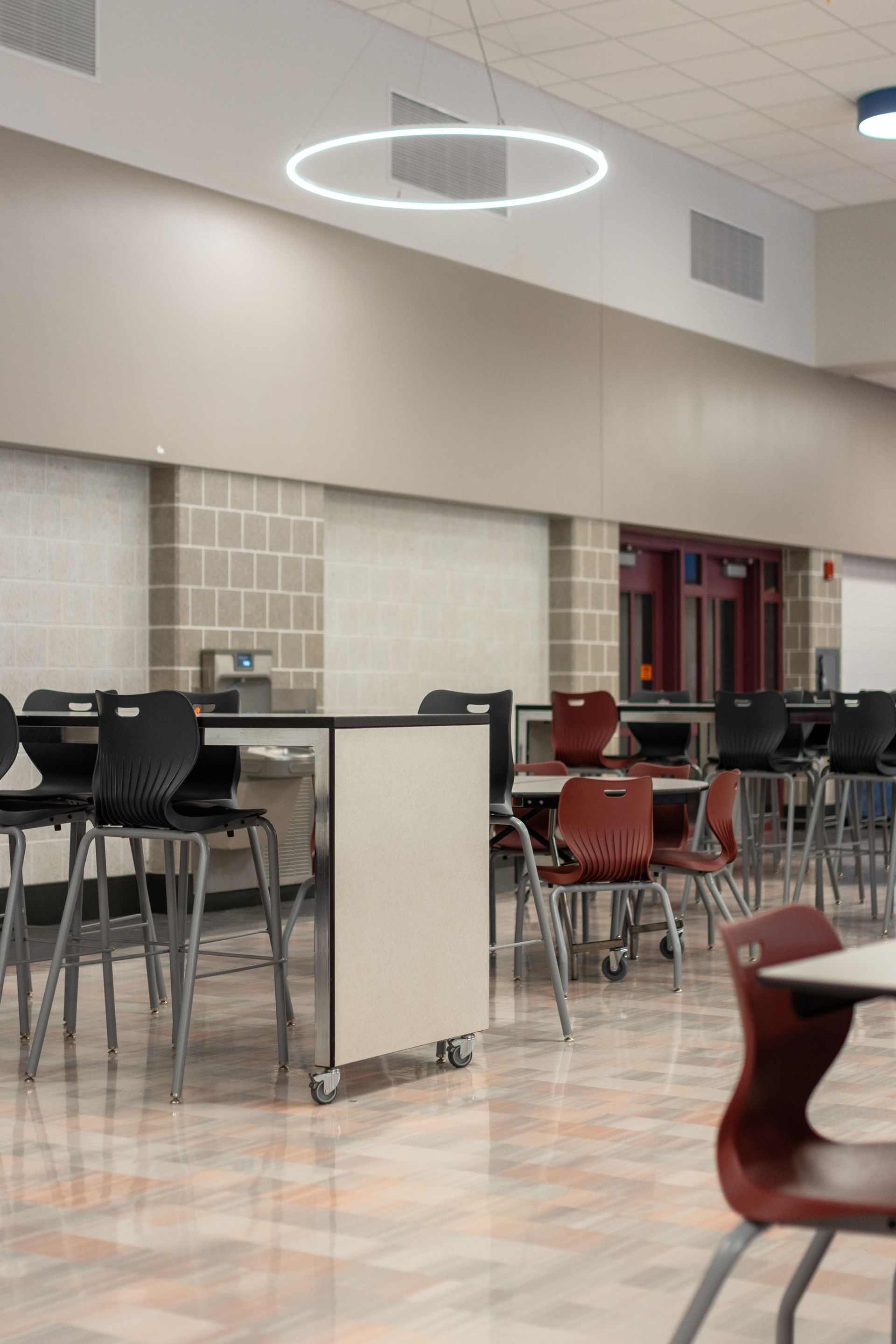 Mount Nittany Middle School Cafeteria with tables, chairs, and a glowing ring light on the ceiling