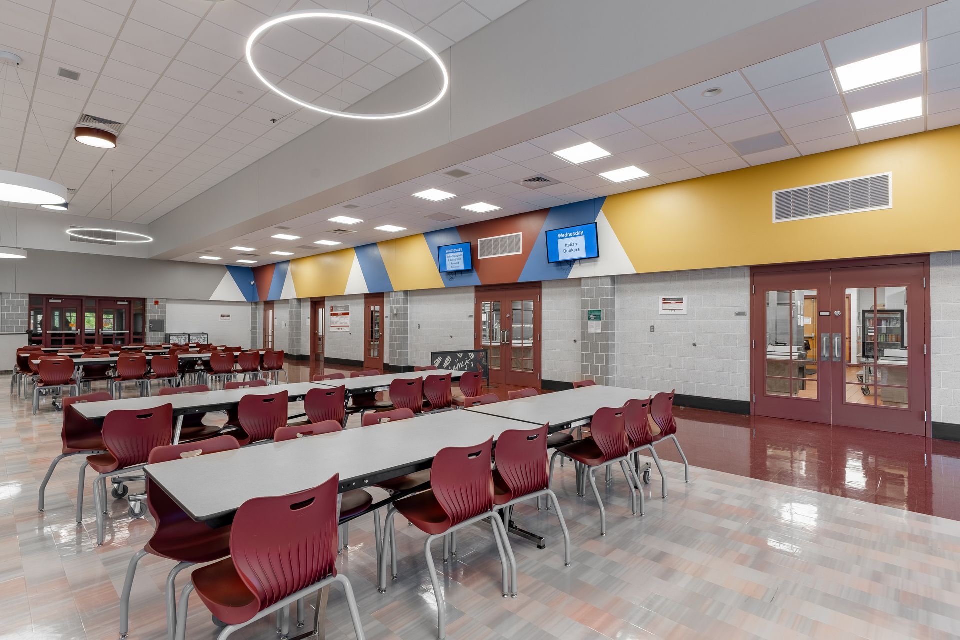 Mount Nittany Middle School Cafeteria with maroon tables and chairs under bright ceiling lights
