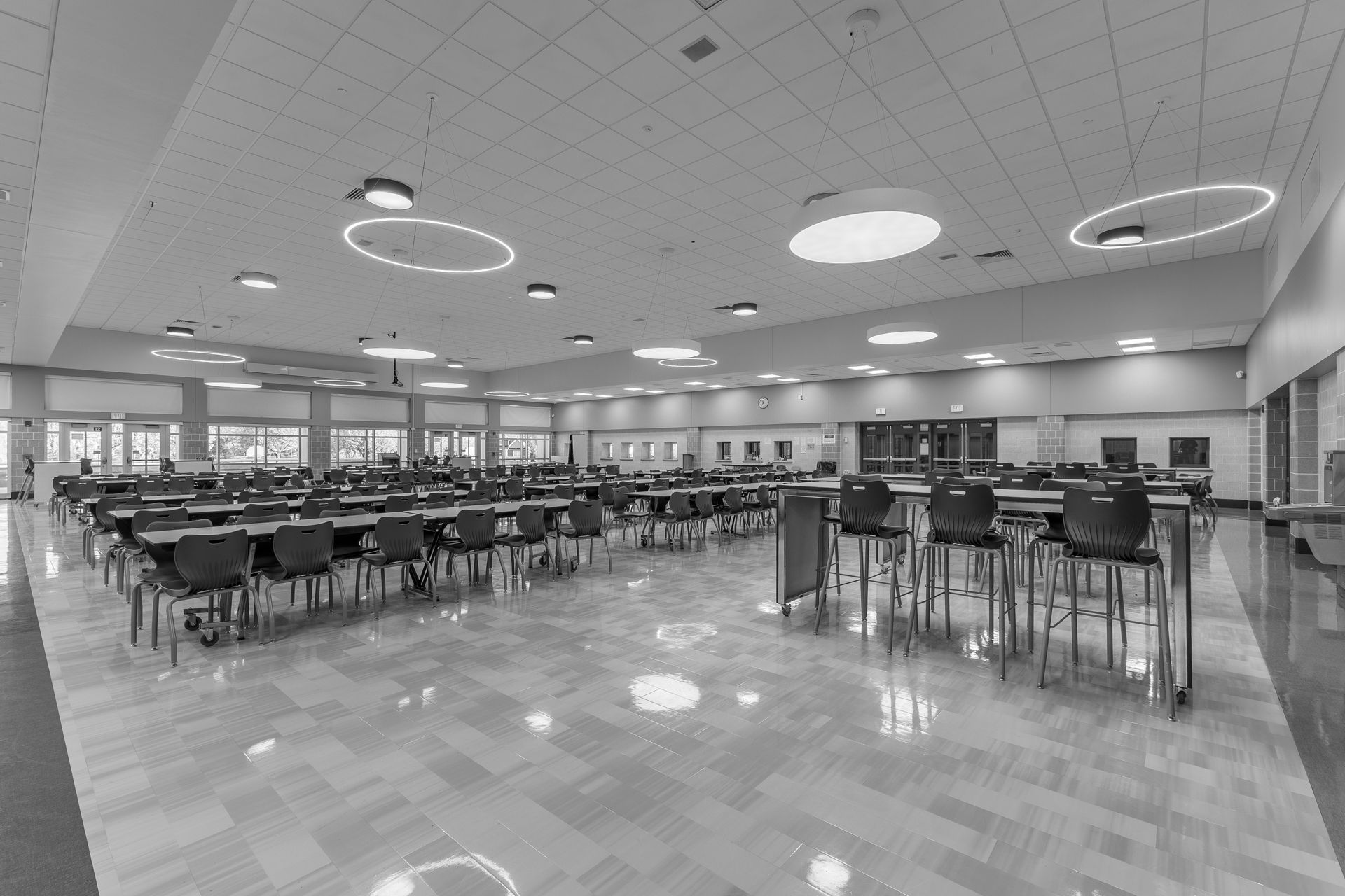 Mount Nittany Middle School Cafeteria with rows of empty tables and chairs under circular ceiling lights.