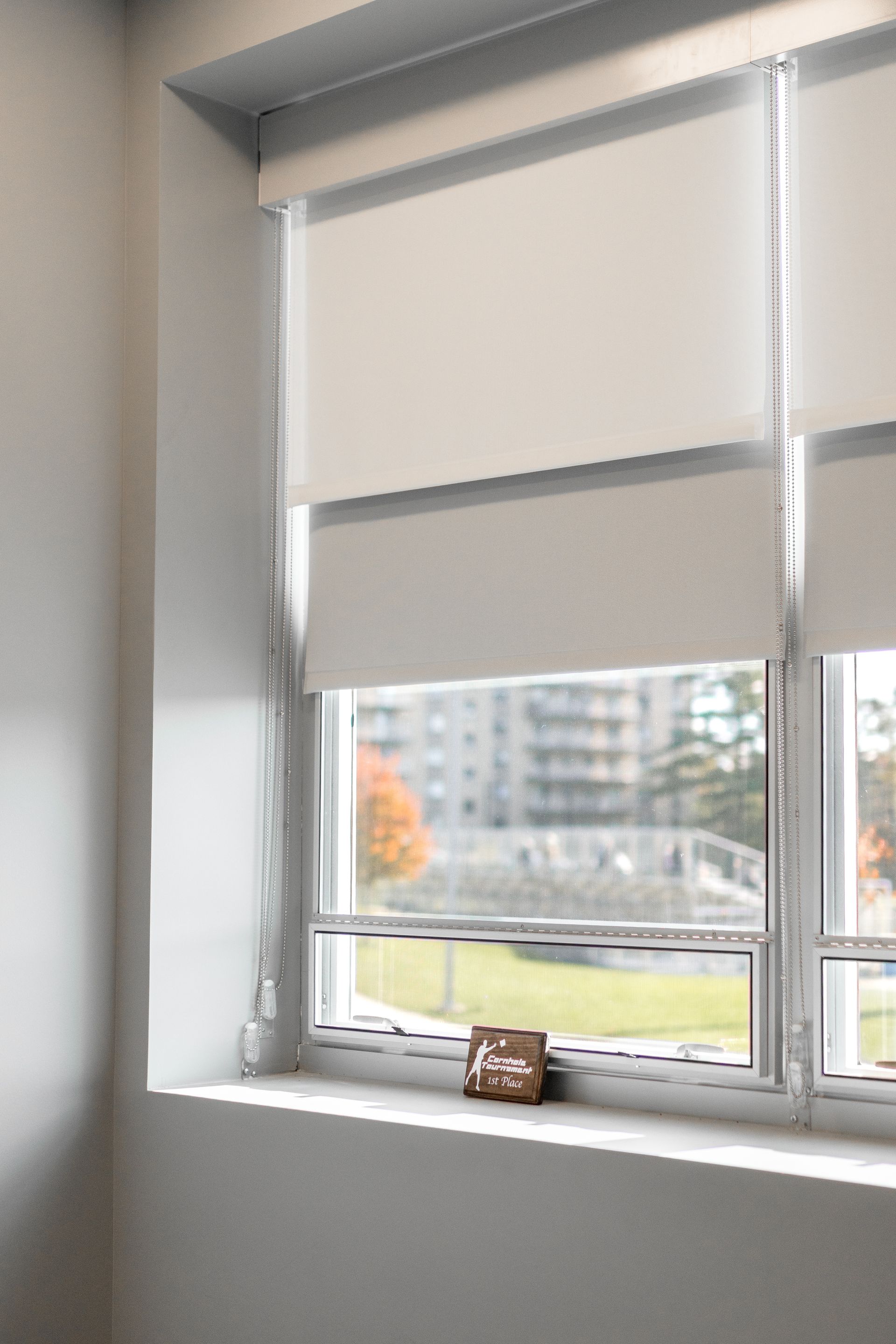 State College Area School District North Building's office window with white blinds and a view of trees and buildings outside