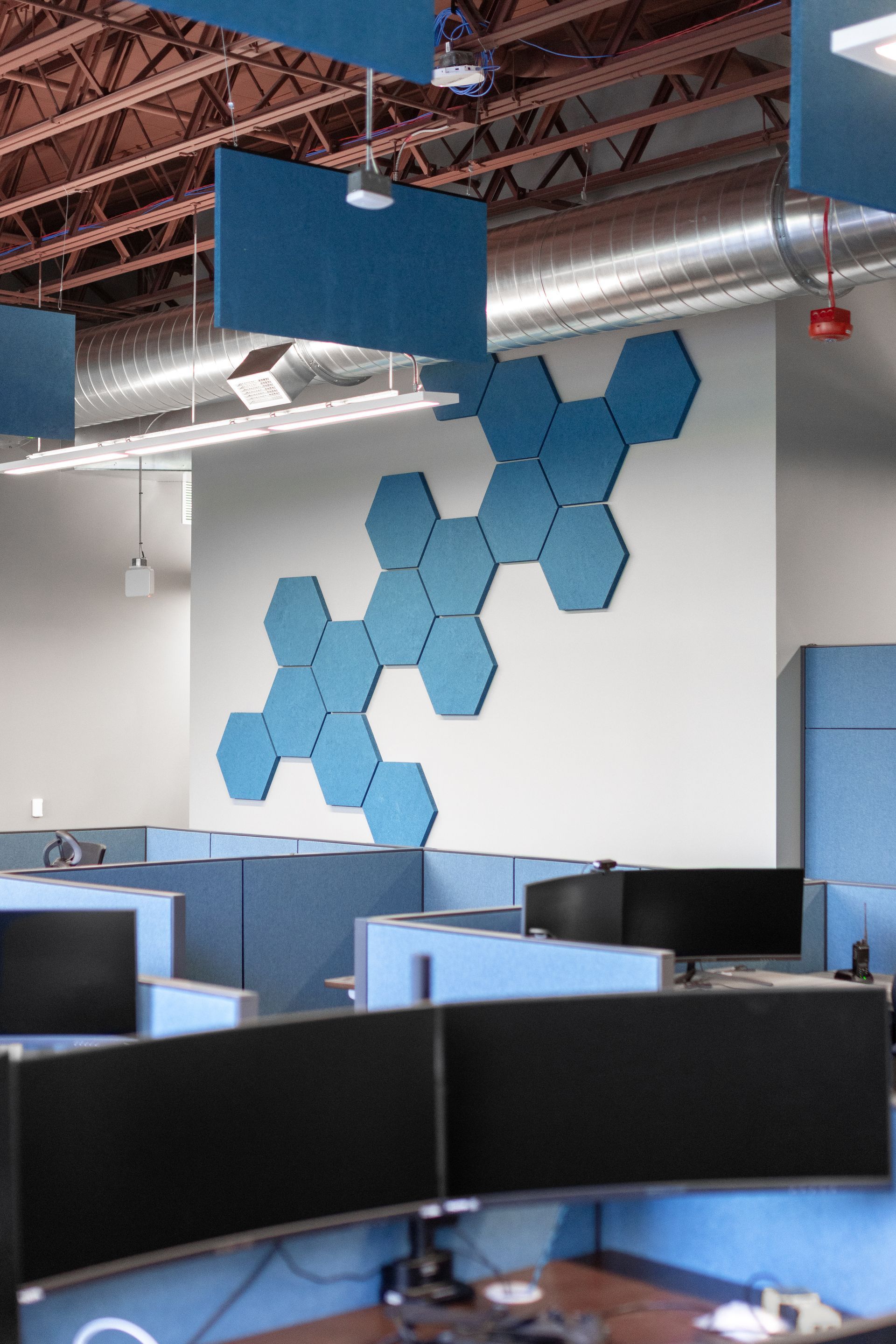 State College Area School District North Building's open office with blue hexagonal wall decor and rows of computer monitors.