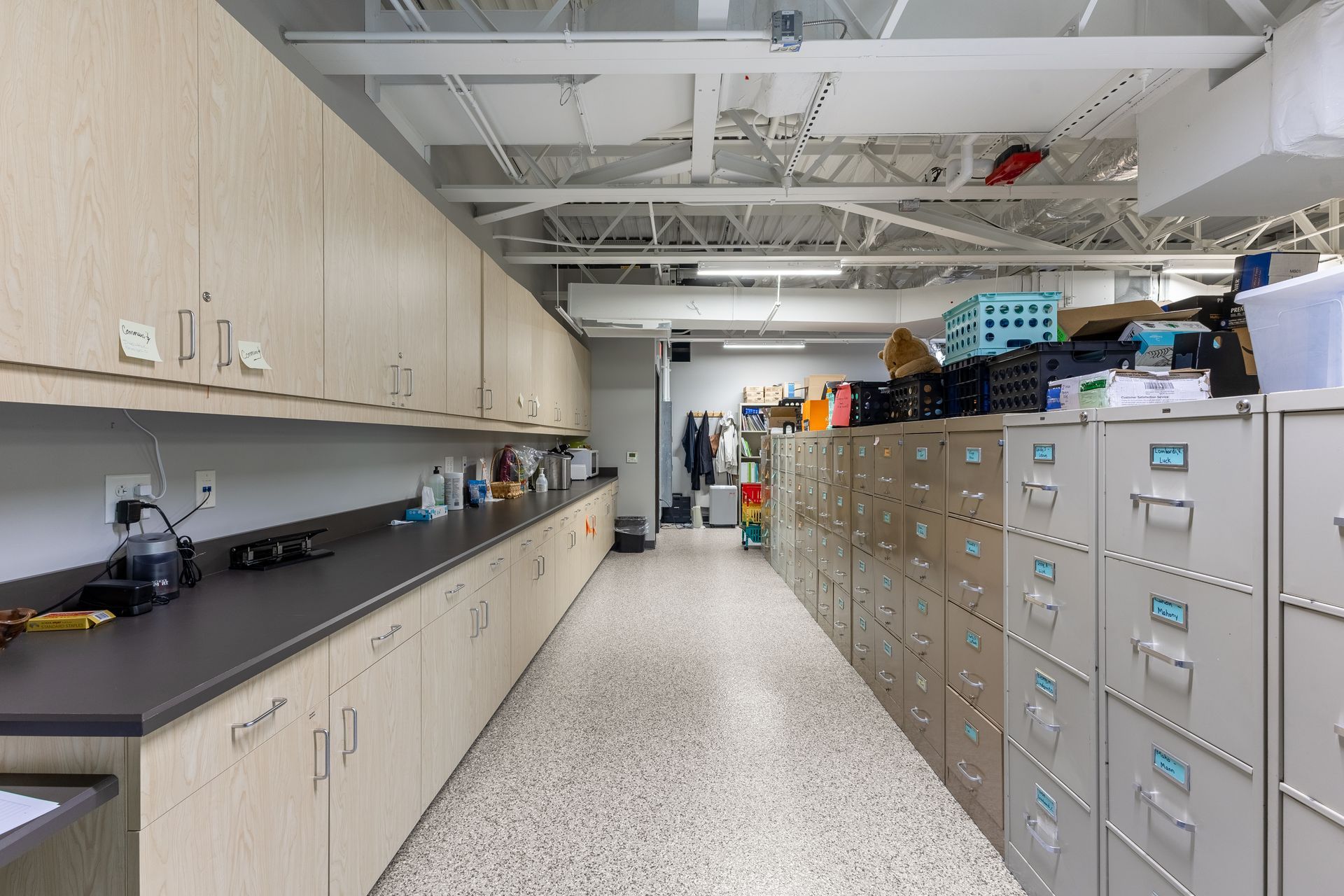 State College Area School District Panorama Village building's laboratory aisle with cabinets, filing drawers, and countertops under fluorescent lights