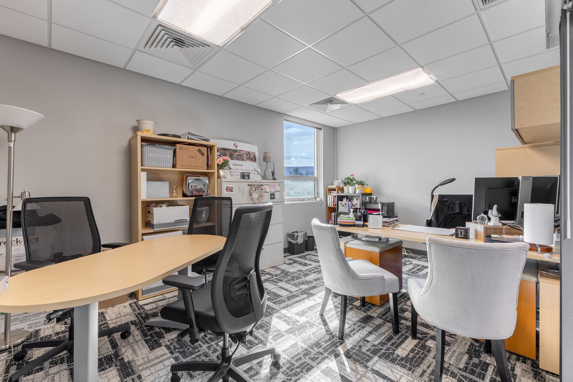 State College Area School District Panorama Village building's modern office with desks, computers, shelves, and chairs under bright ceiling lights