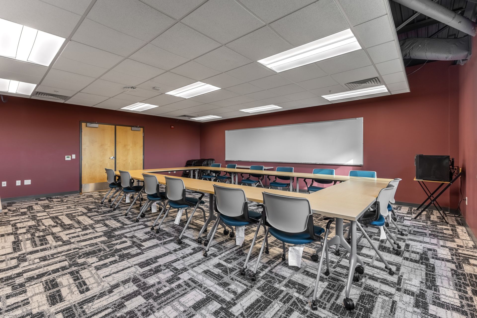 State College Area School District Panorama Village building's empty classroom with rows of chairs, tables, whiteboard, and wooden doors