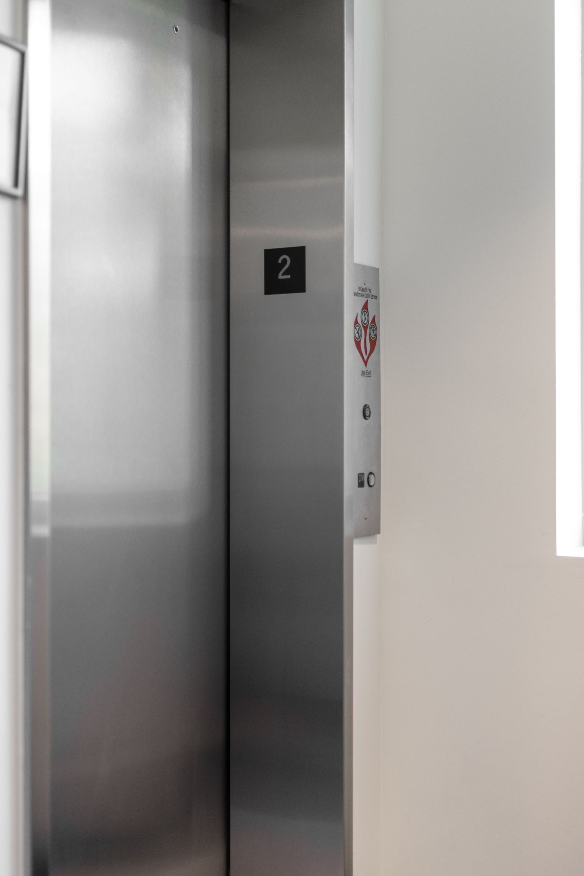 State College Area School District Physical Plant Building's elevator doors closed at floor 2, with a call panel beside them.