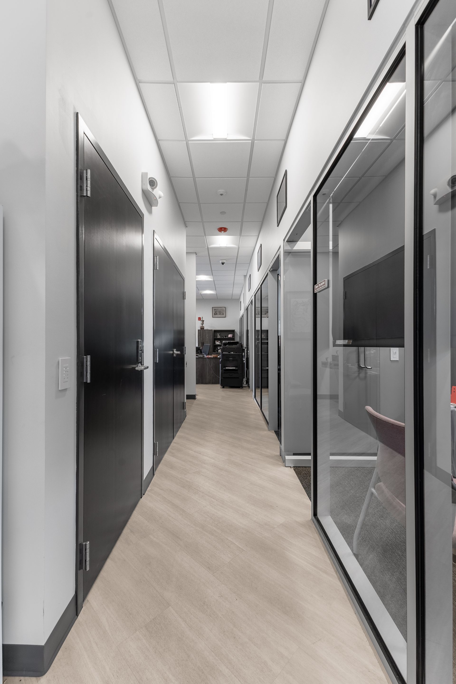 State College Area School District Physical Plant Building's hallway with glass-walled rooms and overhead lights