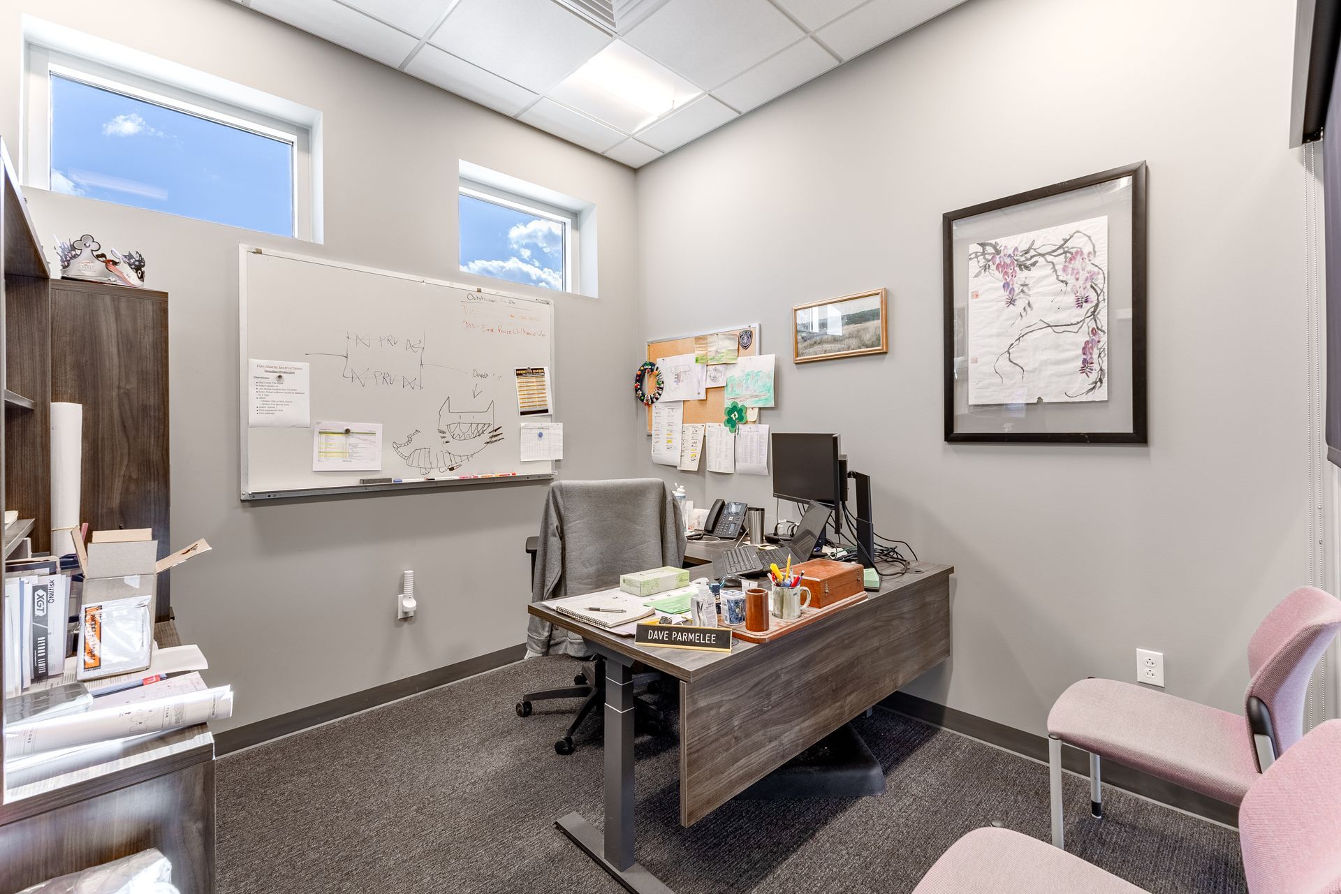 State College Area School District Physical Plant Building's office with a desk, whiteboard, exam chair, and wall art in a bright room