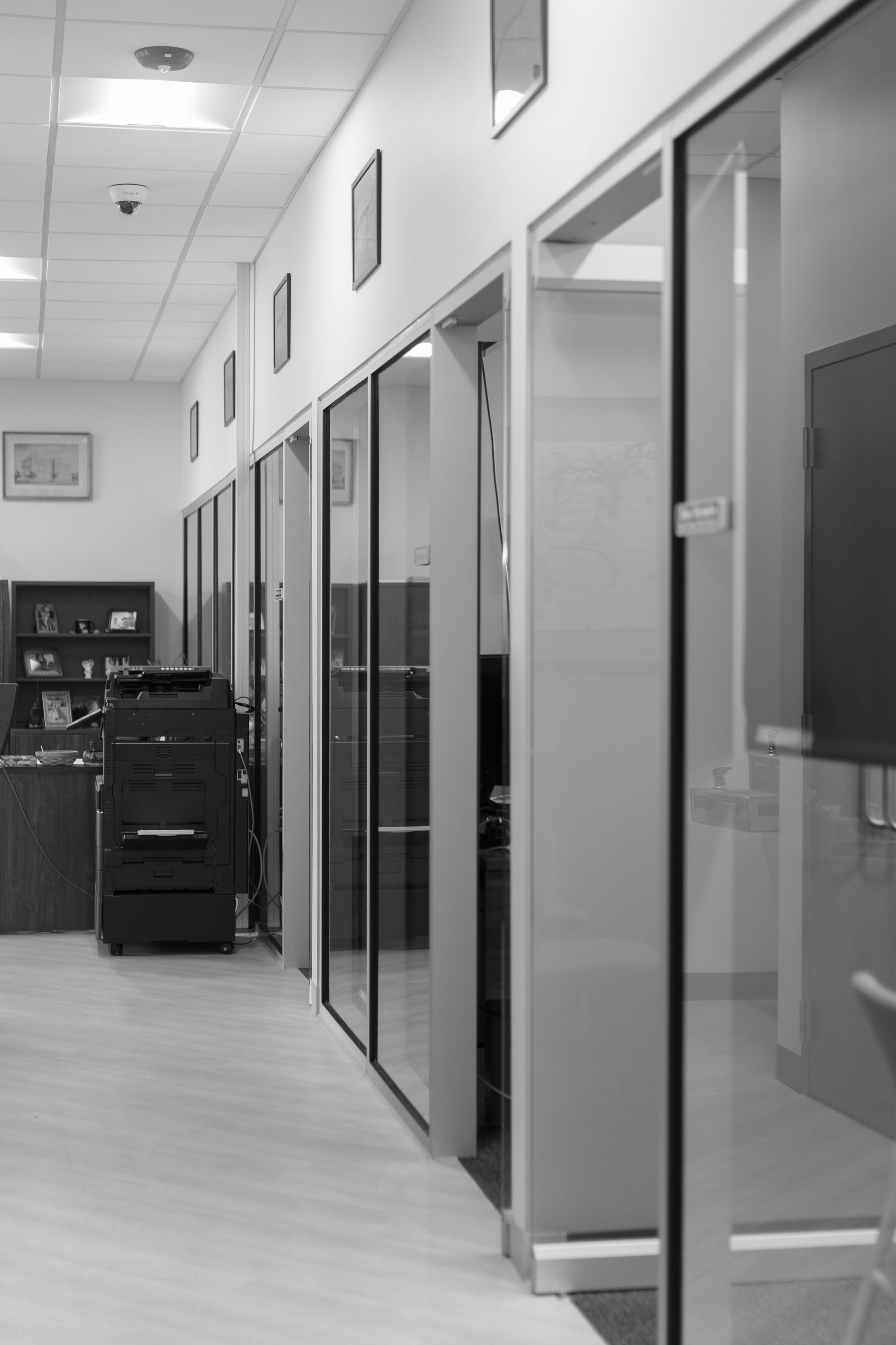 State College Area School District Physical Plant Building's office hallway with glass-walled rooms and a filing cabinet along the left wall