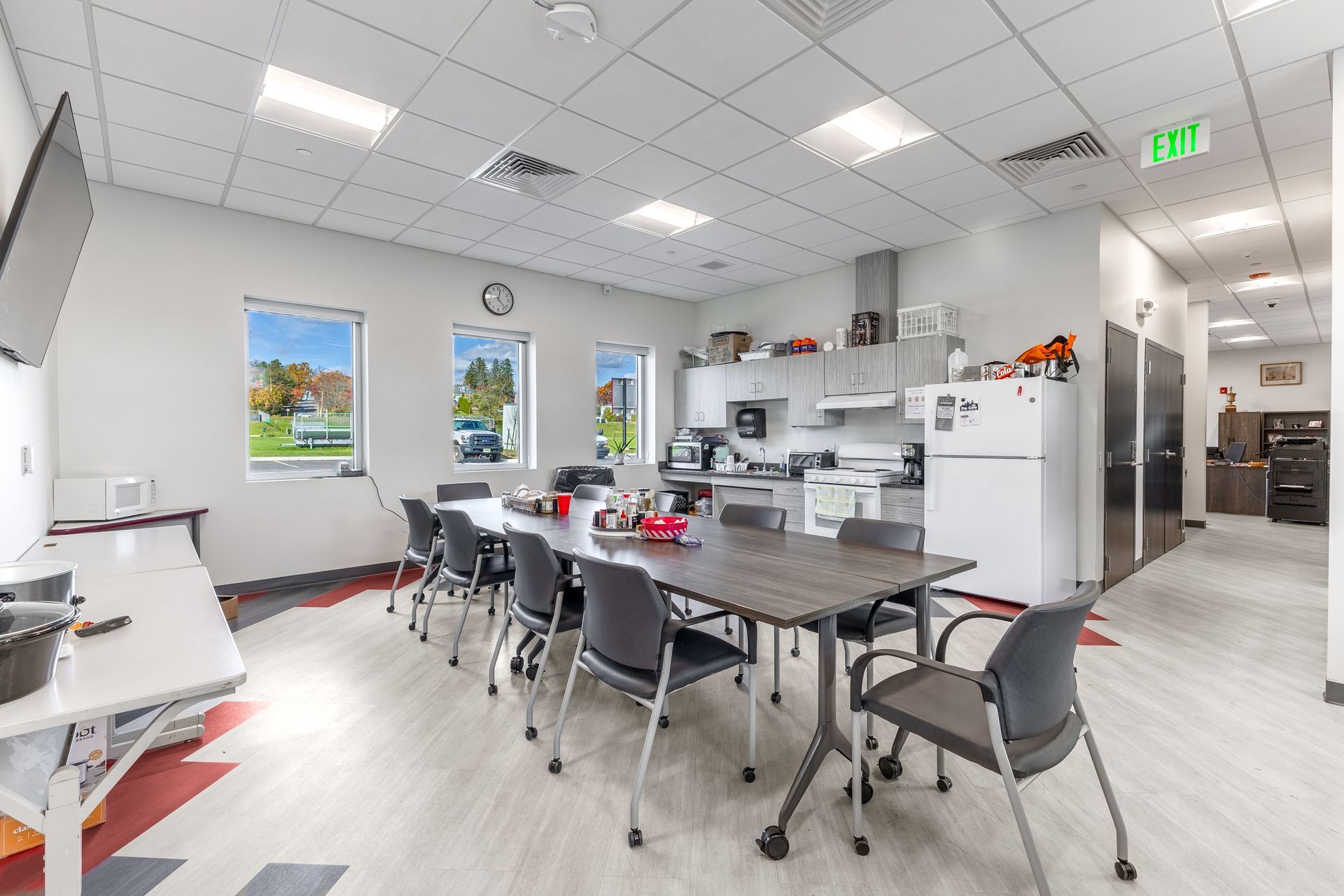 State College Area School District Physical Plant Building's office kitchen with tables, chairs, white cabinets, and daylight from windows