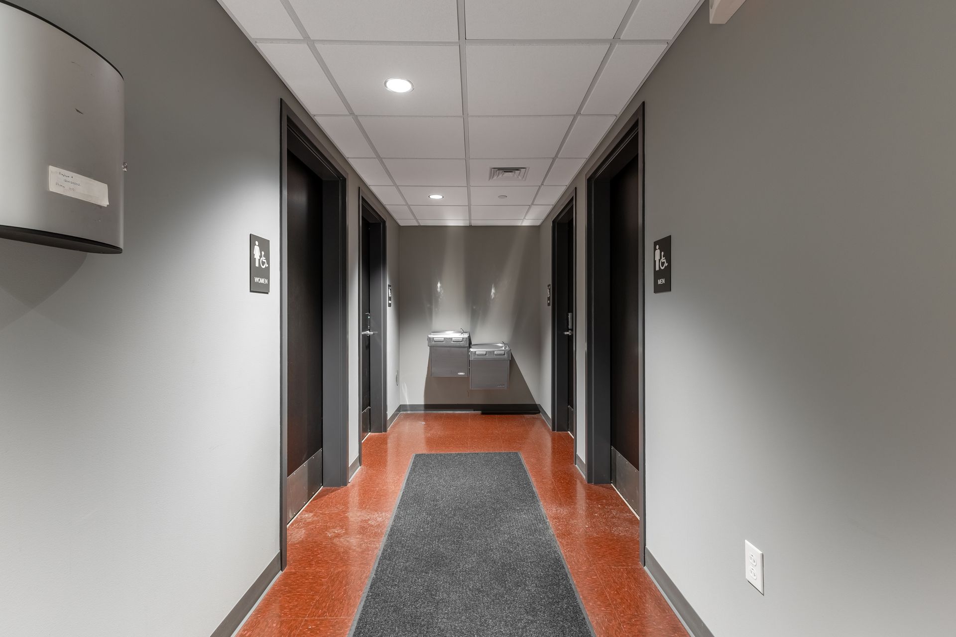 State College Area School District Physical Plant Building's office hallway with gray walls, red floor, and dark doors on both sides