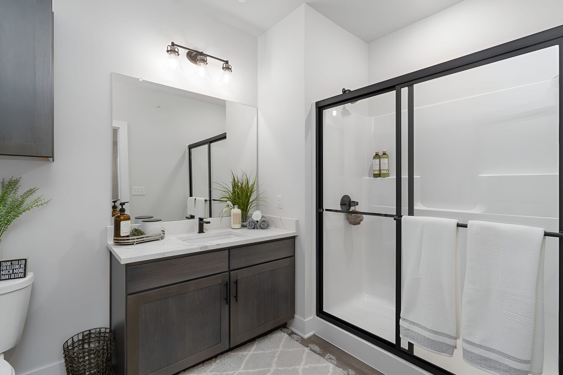 Sleek master bathroom in luxury one bedroom apartment for rent with glass-enclosed shower