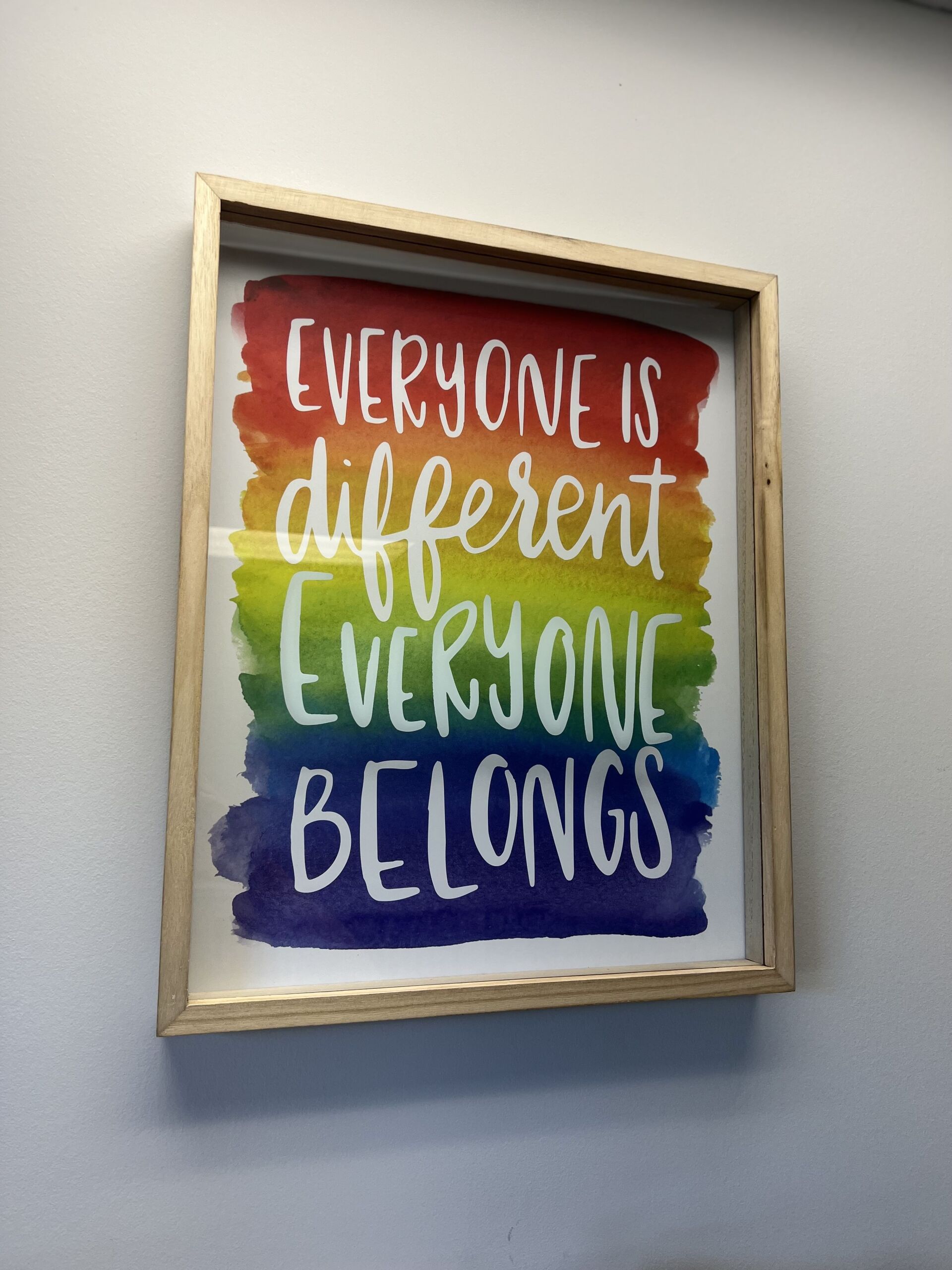 A framed poster that says everyone is different everyone belongs