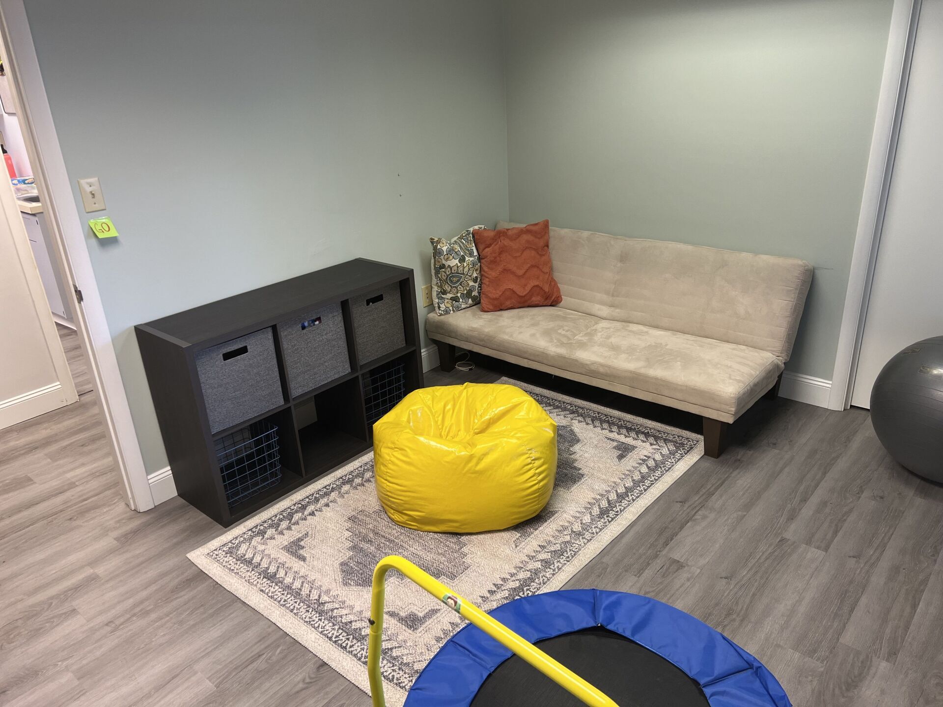 A living room with a couch , bean bag chair , and trampoline.