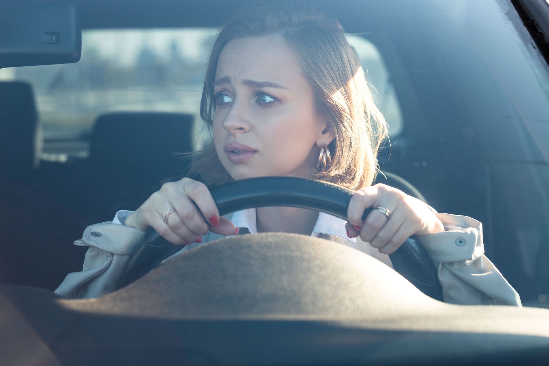 Woman gripping steering wheel, looking fearful while driving. Woman gripping steering wheel, looking fearful while driving.