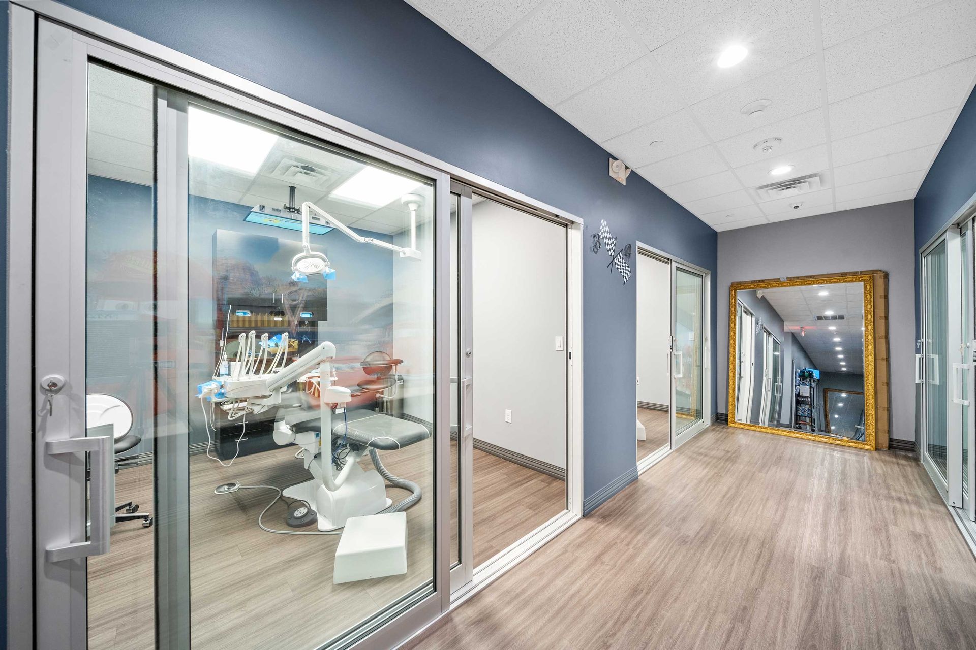Grand Prix Dental in Katy, TX A dental office with a dental chair and a mirror in the hallway.