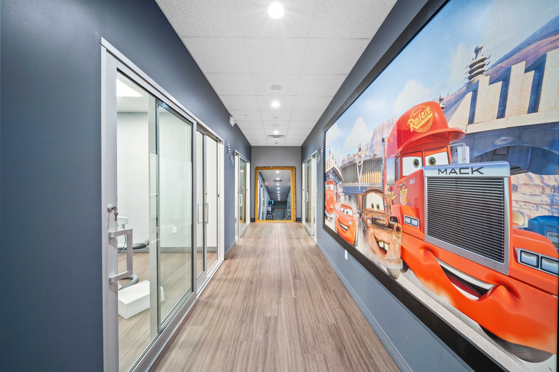 Grand Prix Dental in Katy, TX A hallway with a picture of cars on the wall.