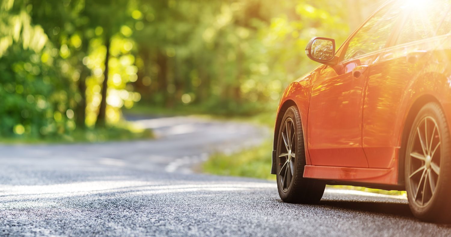 Orange car driving in Spring in Lawrence KS | GenAuto