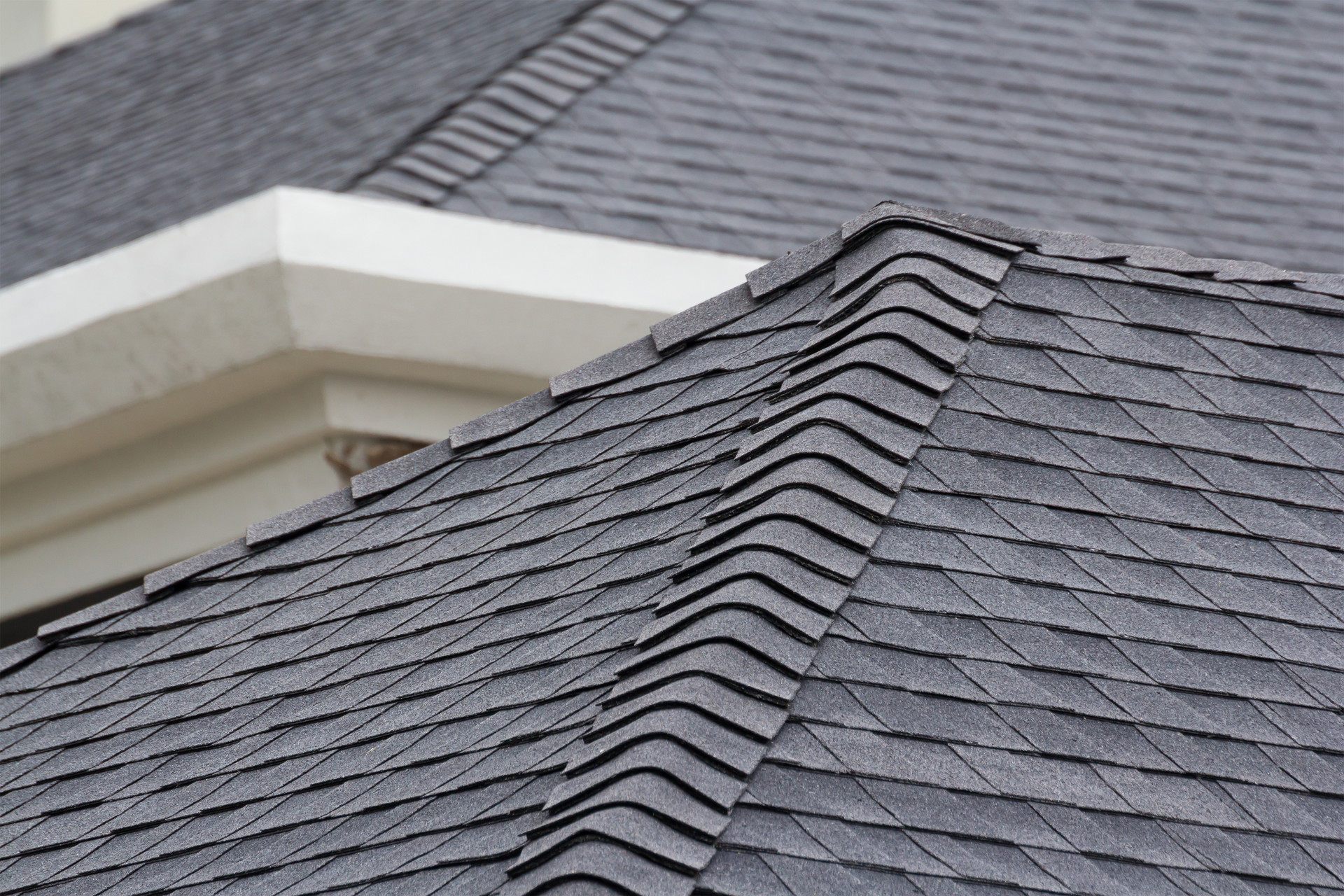 A close up of a Bakersfield roof with a gutter on it.