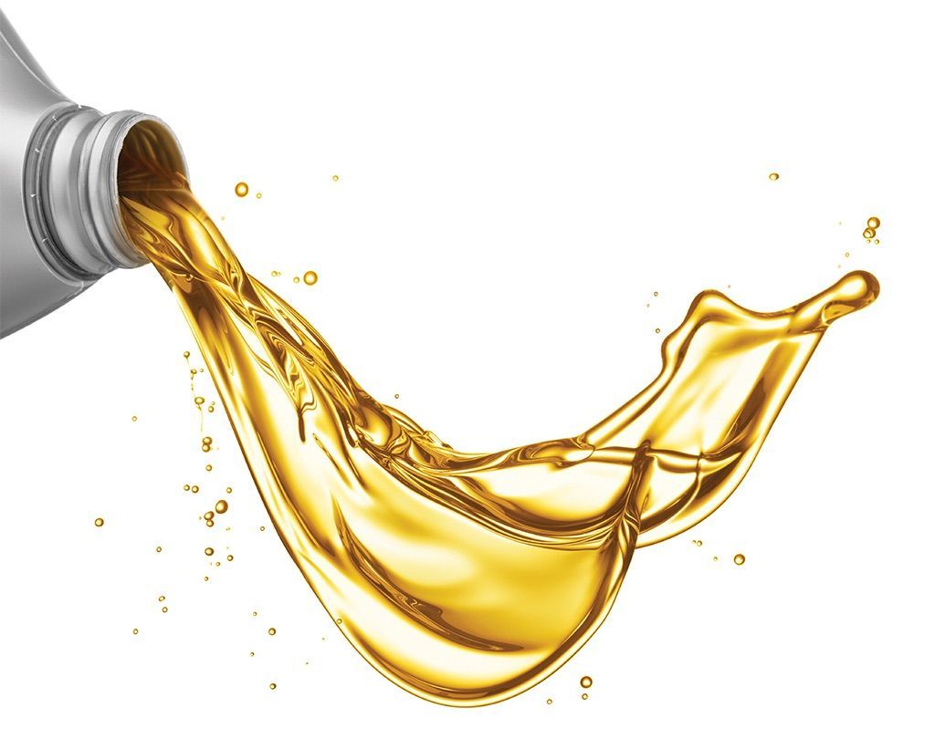 Motor oil pouring from a gray bottle, creating a golden splash against a white background.