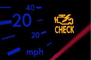 Illuminated orange check engine light on a car dashboard.