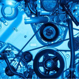 Blue-toned close-up of an engine with belts, pulleys, and various mechanical components.