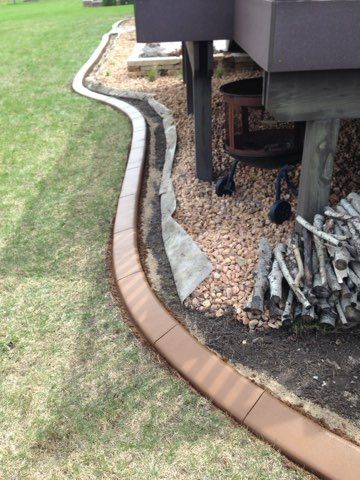 Curved sidewalk curb ramp with yellow tactile warning strips and gray concrete at a street corner