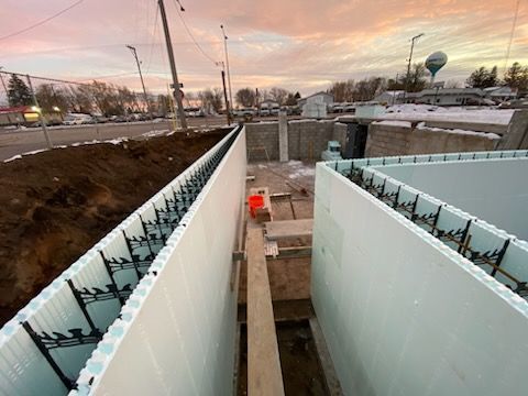 Empty unfinished concrete interior with rows of pillars and large windows