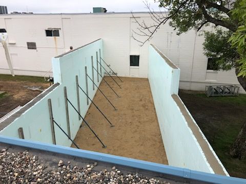 Gloved hand smoothing wet concrete with a trowel on a construction site