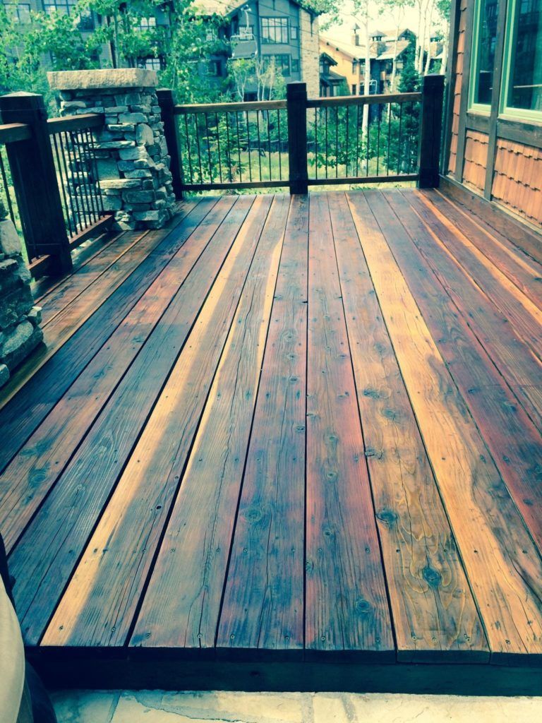 a wooden deck with a railing and a waterfall in the background .