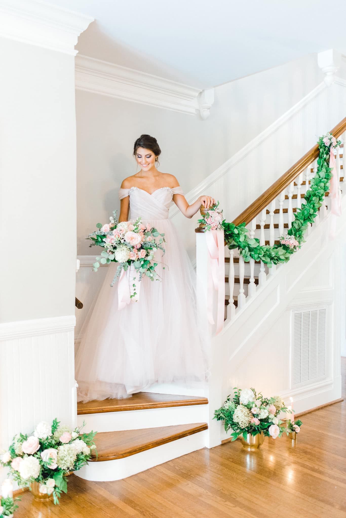 bride on stairs with floral garland