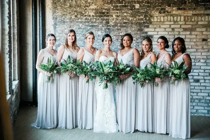 bridesmaids and brides holding flower arrangements