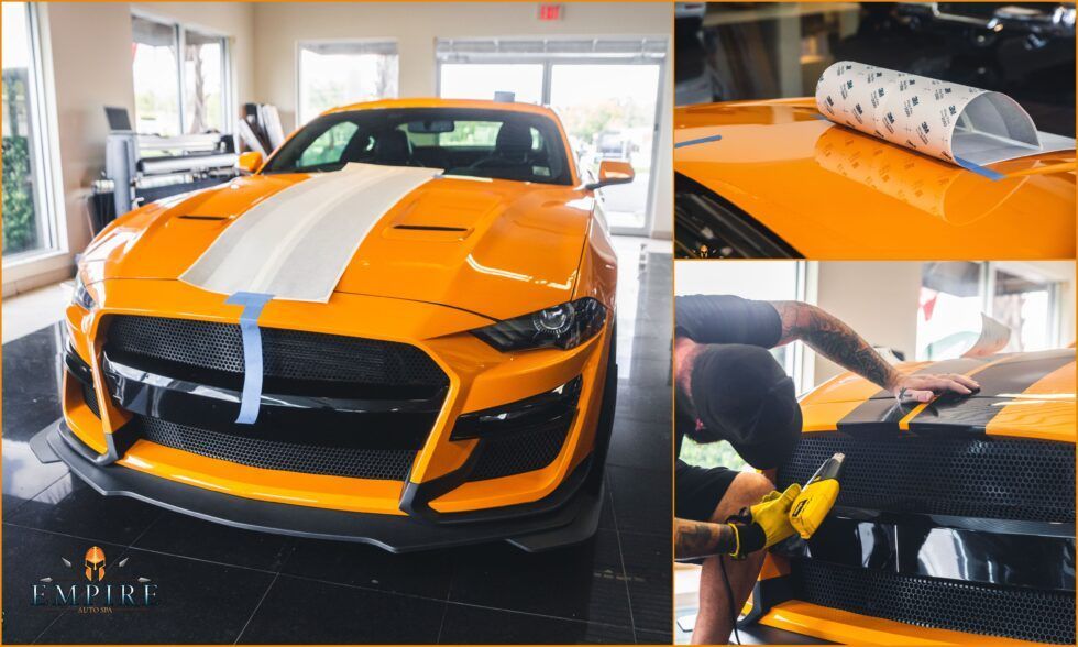 A man is wrapping a yellow mustang with white stripes.