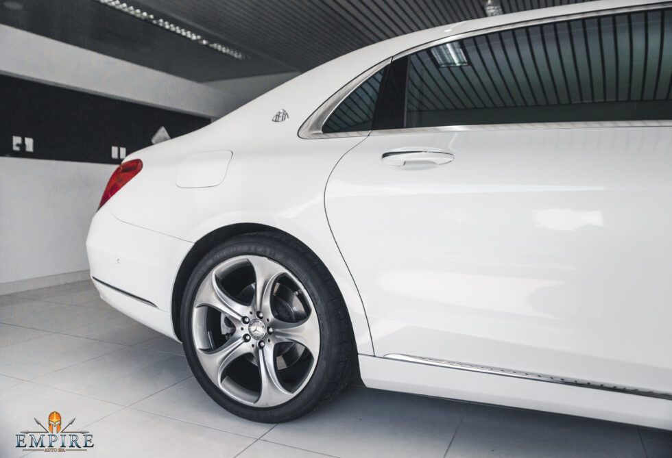 A white mercedes benz is parked in a showroom