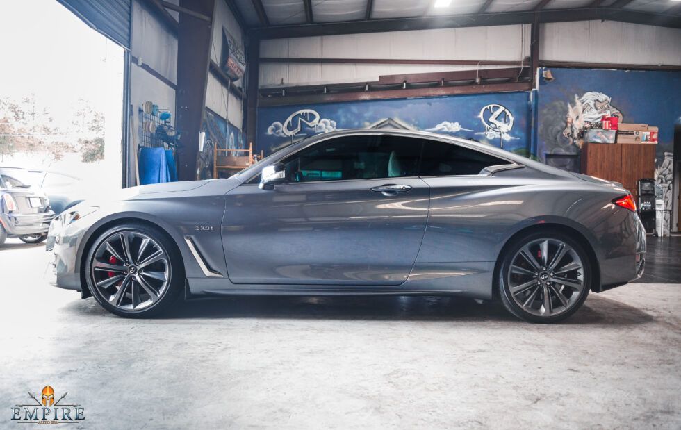 A gray sports car is parked in a garage.