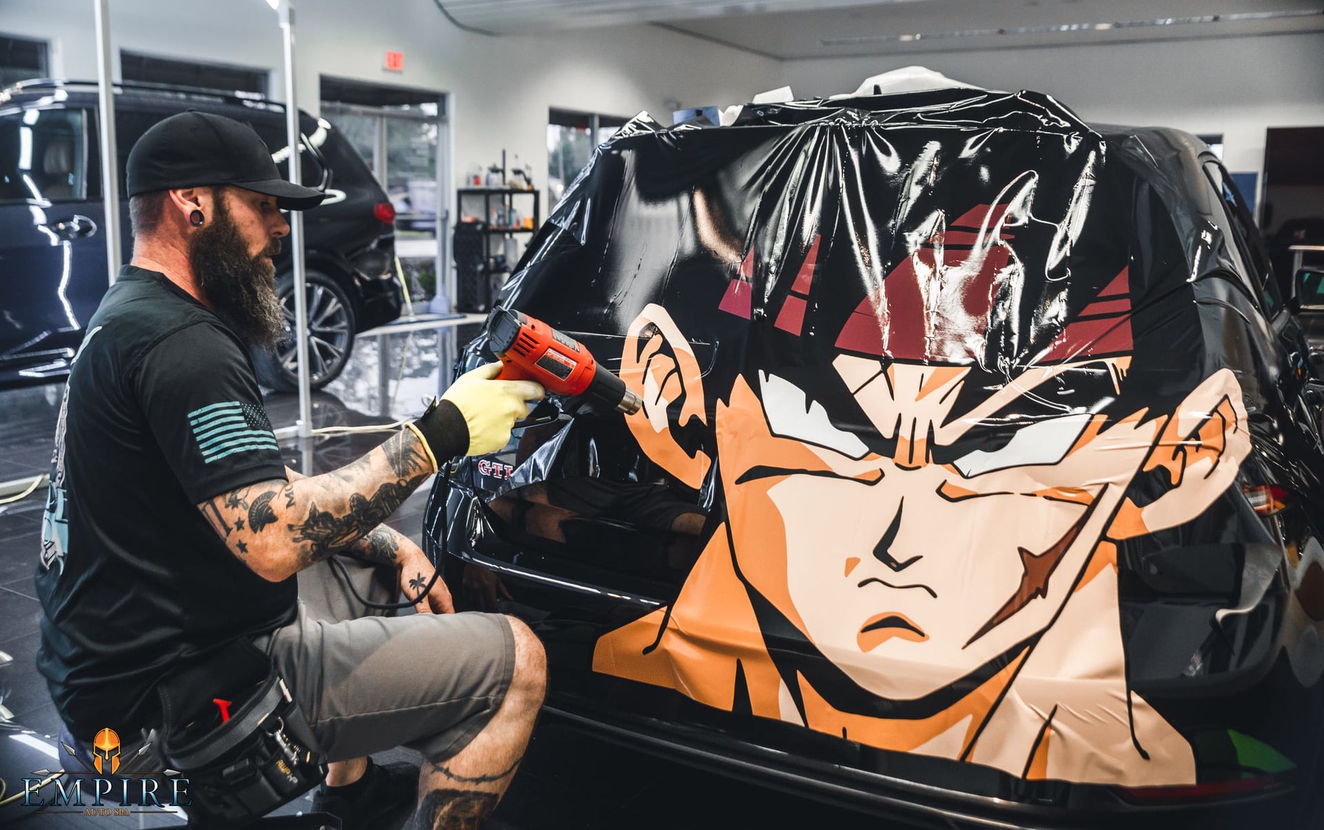 A man is wrapping a car with a cartoon character on it.