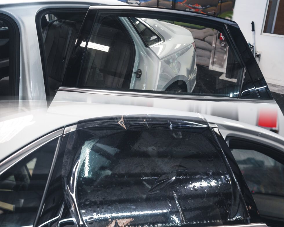 A white car is parked next to a black car