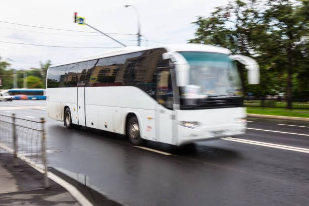 Tourist bus moving along city street, showcasing charter bus transportation in an urban setting.