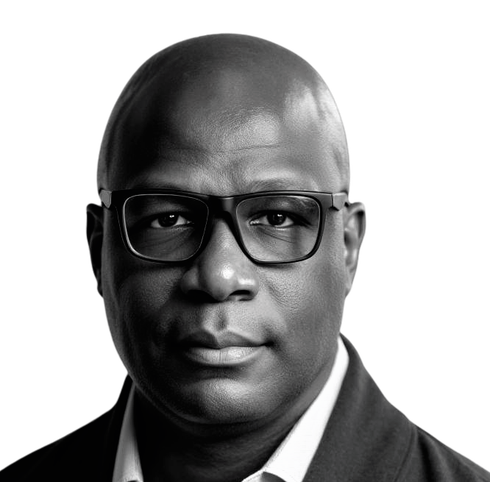 A bald man wearing glasses and a black shirt is looking at the camera.